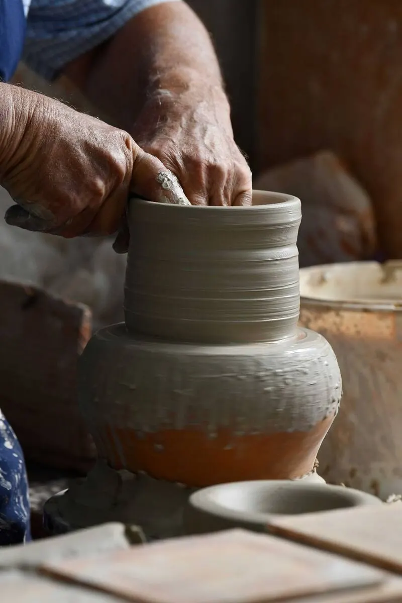 Hands centring clay on the pottery wheel in the Dizayn74 studio