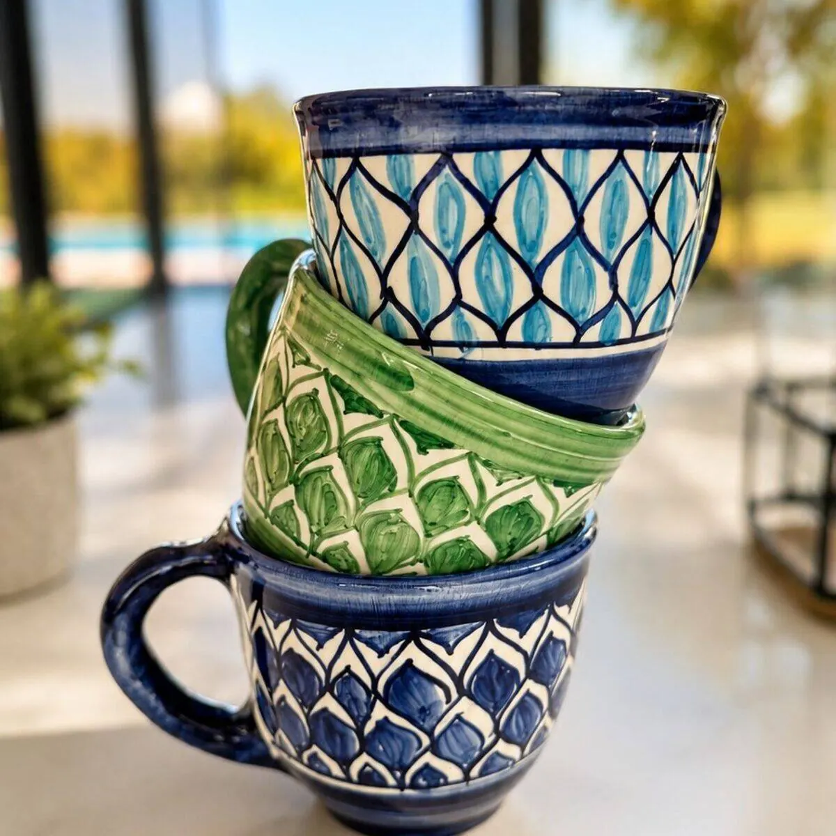 Stack of three hand-painted ceramic coffee cups in blue and green leaf patterns by Dizayn74