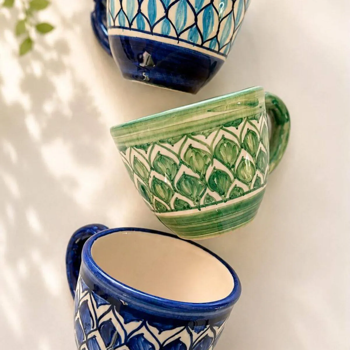 Three hand-painted ceramic coffee cups in cobalt, turquoise and green leaf patterns by Dizayn74
