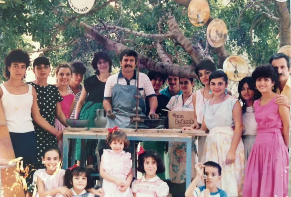 The Dizayn74 team and family gathered around the potter's wheel under a tree in Kyrenia